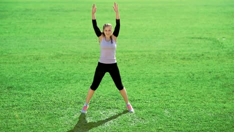 Schlanke-sportliche-Frau,-die-Übungen-auf-dem-grünen-Rasen