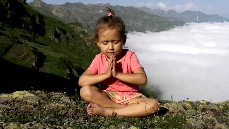 Kleine-süße-Mädchen-meditieren-auf-Berg