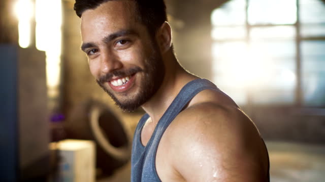 Handsome-Sweaty-Muscular-Man-Smiles-on-Camera.