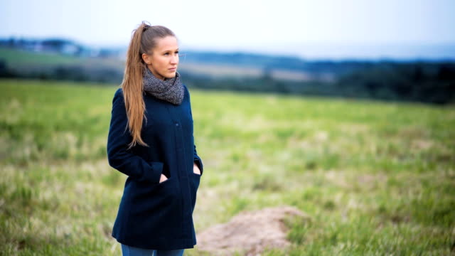 Portrait-of-lonely-depressed-woman-alone-in-a-field