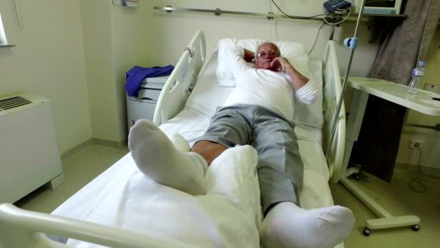 Senior-old-man-patient-Lying-Relaxing-In-Hospital-Bed