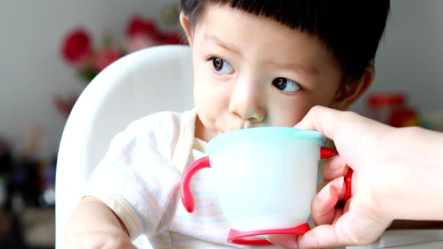 niedliche-Baby-Boy-Trinkwasser-aus-Stroh-im-Training-cup