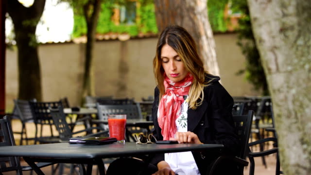 Retrato-de-sonriente-empresaria-con-teléfono-móvil-trabajo-en-café,-al-aire-libre