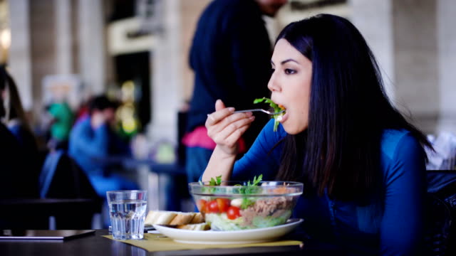 nachdenklich-und-einsamen-philippinischen-Frau-essen-Salat-in-einem-Restaurant-sitzen