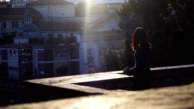 Porträt-der-nachdenkliche-junge-Frau-beobachtet-den-Sonnenuntergang-über-Rom