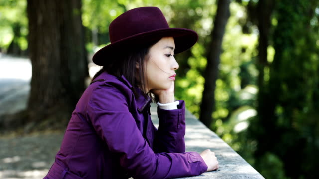 sad,-thoughtful-young-asian-woman-looking-in-camera,outdoor