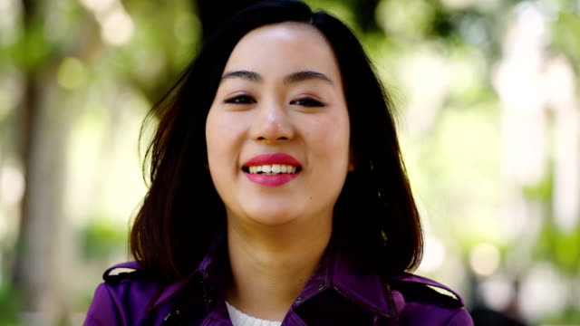 mujer-asiática-feliz-sophistacted-en-la-calle-smaling-a-la-cámara