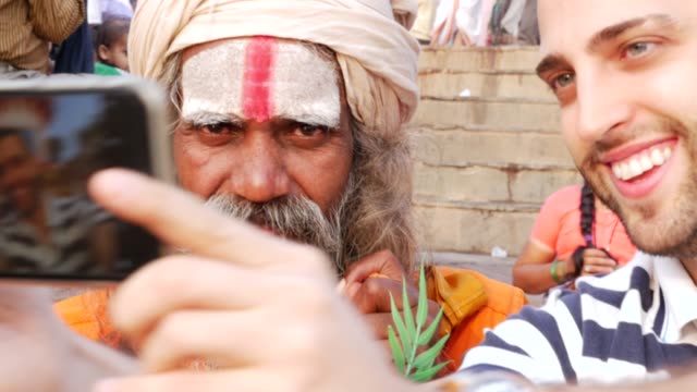 Turista-tomando-una-selfie-con-Sadhu---hombre-santo,-en-Varanasi,-India
