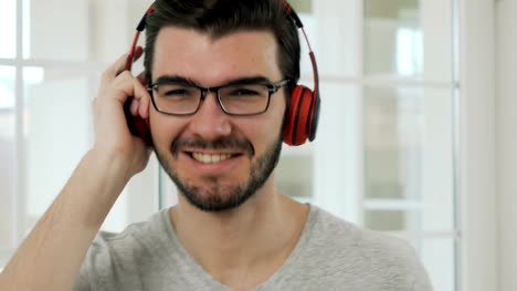 Hübscher-Kerl-in-Brillen-hört-Musik-im-Kopfhörer