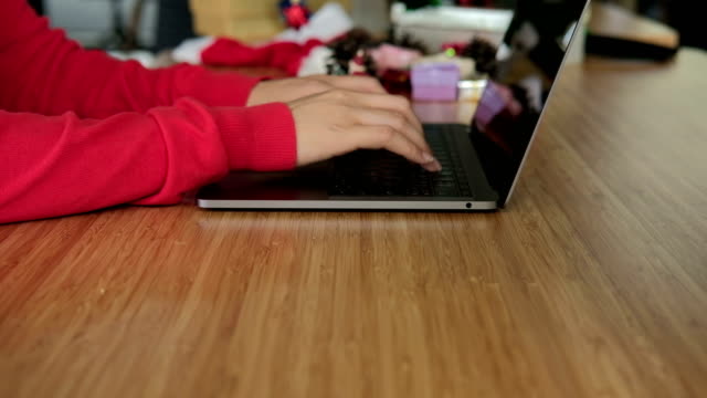 asiatische-Frau-Verwendung-Computer-zu-Hause.-Mädchen-mit-Weihnachtsbaum-im-Weihnachtsurlaub.-Silvester-Feier.-Saison-Grüße