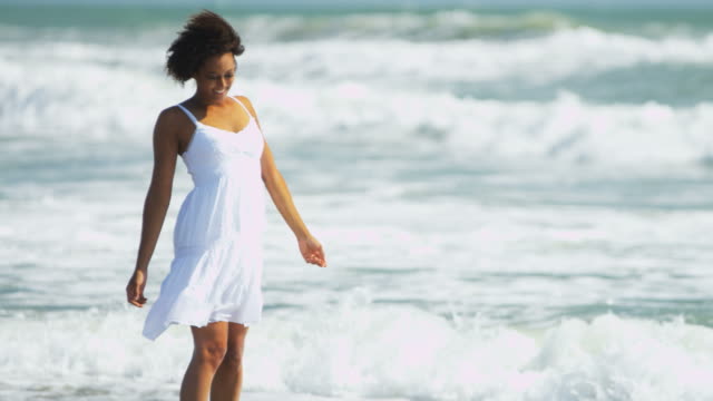 Portrait-of-attractive-woman-enjoying-waves-on-beach