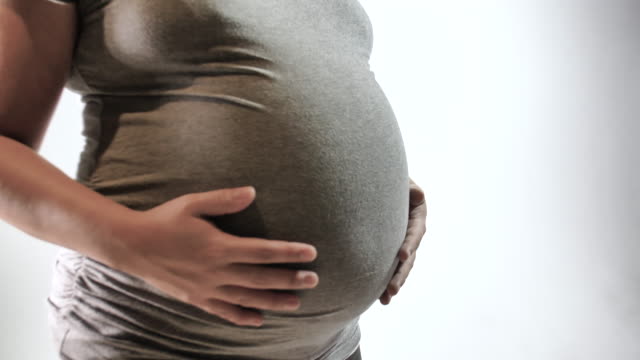 Concepto-de-embarazo-madre-frotamiento-vientre-con-manos-blanco-aislado-fondo
