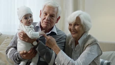 Großeltern-mit-Baby-Blick-in-die-Kamera