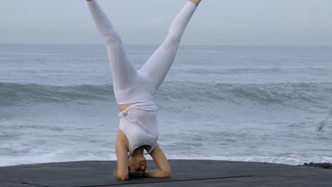 Woman-Practicing-Handstand-on-Coastline