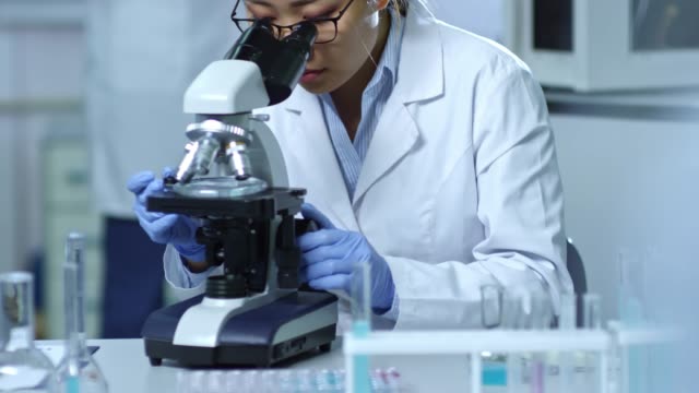 Mujer-científico-utilizando-microscopio