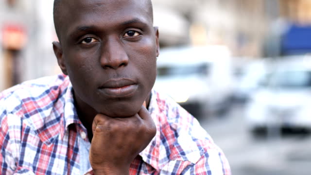 Pensive-young-black-african-man-looking-at-camera,-close-up