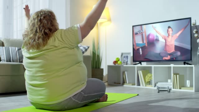 Plus-Size-Woman-Doing-Yoga-with-Online-Instructor