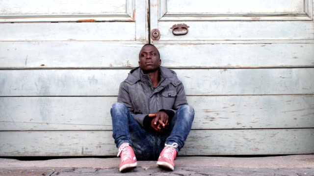 traurige-nachdenkliche-schwarz-afrikanischer-Einwanderer-allein-im-Boden-sitzen