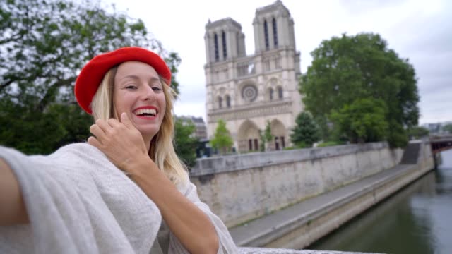 4K-Young-woman-taking-selfie-in-Paris-at-city-Notre-dame-using-mobile-phone