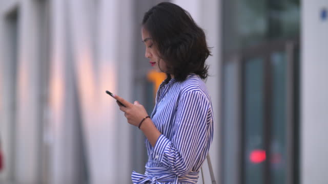 Pretty-woman-using-phone-in-the-city,-4k