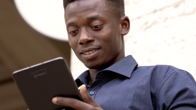Lächelnd-schwarzen-amerikanischen-Studenten-mit-Tablet-auf-der-Straße