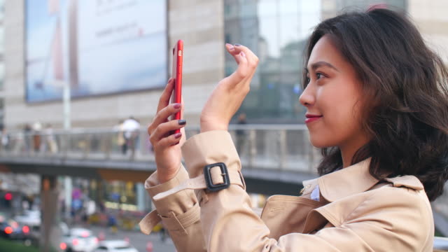 video-de-mujer-bastante-asiática-charlando-por-teléfono-en-la-ciudad