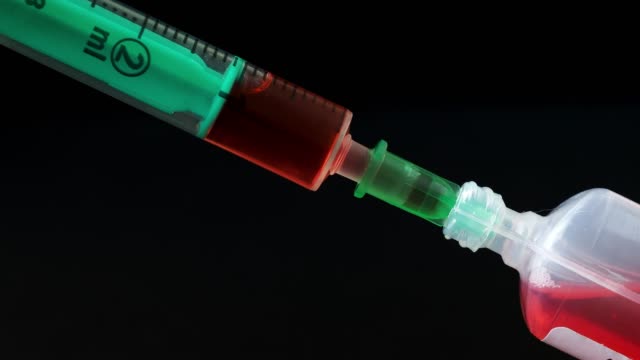 Plastic-medical-syringe-with-needle-and-plastic-vial.-Medical-injection-concept.-Medical-equipment.-4k-resolution.