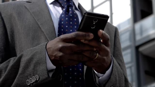 Beschäftigt-schwarze-Geschäftsmann-Tippen-auf-seine-Smartphone-Close-up
