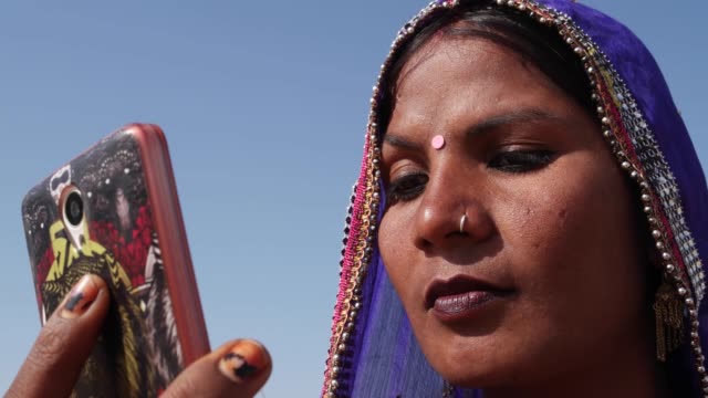 Hermosa-mujer-de-Rajasthani-utilizando-su-teléfono-celular-inteligente-como-un-espejo