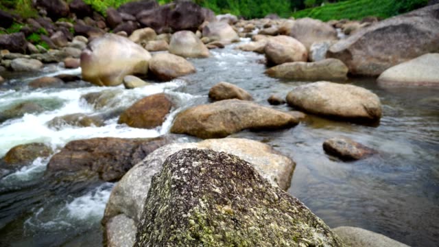 Natur-Wasser-Strömung-vom-Berg-passieren-viele-Felsen-zum-Fluss-in-dem-kleinen-Dorf.-Rauschen-des-Wasserfalls-fiel-entspannen-Sie-sich-ruhig-und-friedlich.