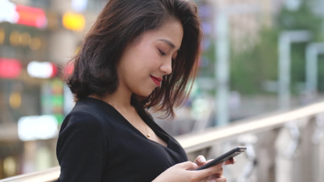 Young-woman-using-phone-in-street