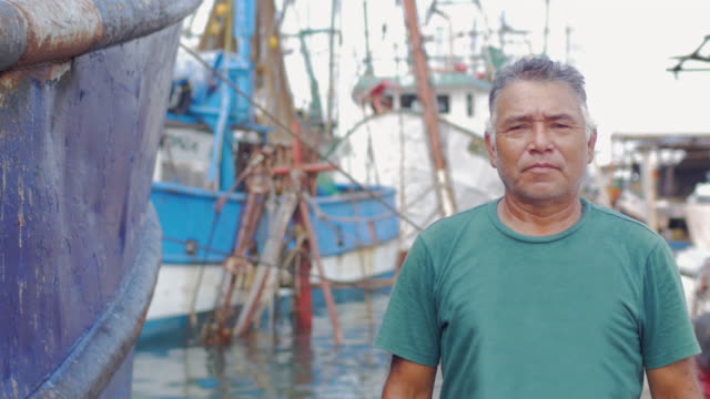 Mid-Schuss-Porträt-eines-älteren-Mannes-hispanic-Erbe-lächelnd-und-Stand-vor-einer-Bootswerft-in-Mexiko