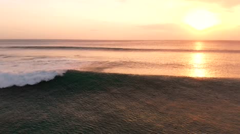 Vista-aérea-con-mar-y-olas-en-el-cálido-atardecer-en-Bali