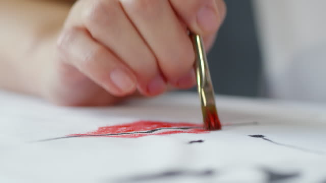 Artist-Dabbing-Red-Paint-on-Image-on-Fabric