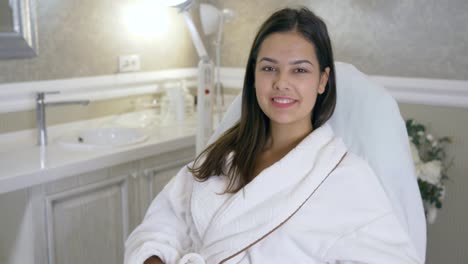 portrait-happy-client-in-beauty-salon,-beautiful-girl-in-bathrobe-lying-on-couch-after-procedure-in-spa