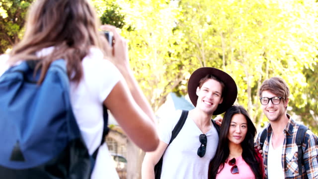 Smiling-woman-taking-picture-to-hipster-friends