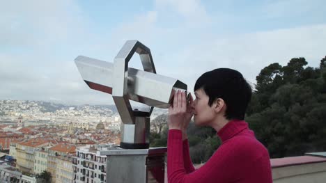 Frau-tourist-stehend-auf-Aussichtsplattform-durch-ein-Teleskop