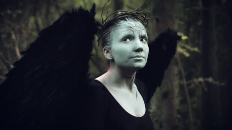 4k-Halloween-mujer-oscura-de-Angel-negro-alas-en-bosque-mirando-hacia-arriba
