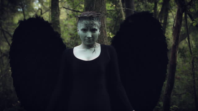 4k-Halloween-Dark-Angel-Woman-with-Black-Wings-in-Forest-Looks-up