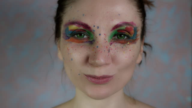 4k-Shot-of-a-Woman-with-Multicoloured-Make-up-Eating-Carrot