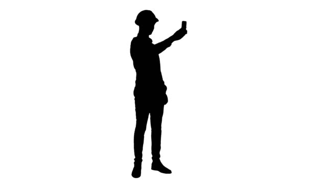 Silhouette-Smiling-construction-worker-using-phone-to-take-selfies