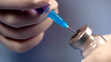 The-syringe-piercing-the-lid-of-the-ampoule