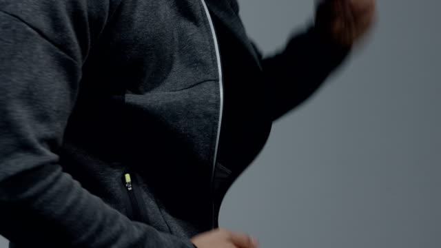 Fitness-Modell-Entpacken-seine-Sweatshirt-mit-Kapuze-aus-der-Nähe
