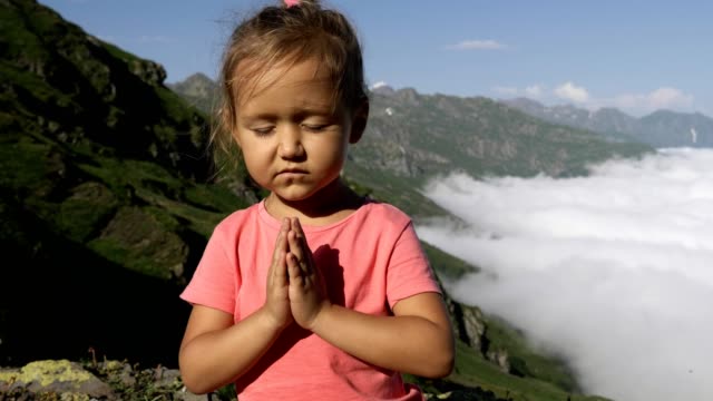 Little-cute-girl-meditating-on-top-of-mountain