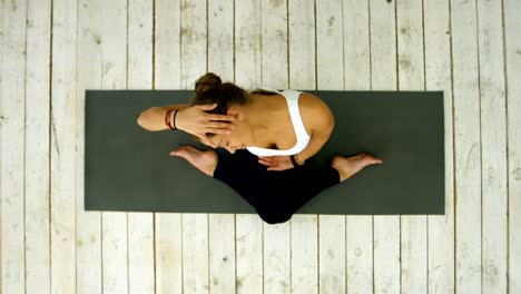 Smiling-woman-stretching-neck-on-mat-in-gym