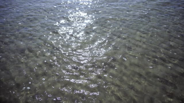 Océano-con-olas-y-arena-en-día-soleado.-Textura-natural