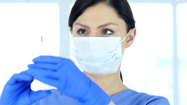 Schließen-der-Arzt-in-Maske-Holding-Injektion-bereit-zu-spritzen
