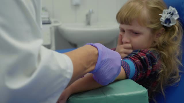 Krankenschwester-übernimmt-Blutprobe-aus-einer-Vene-in-den-Arm-des-kleinen-Mädchens
