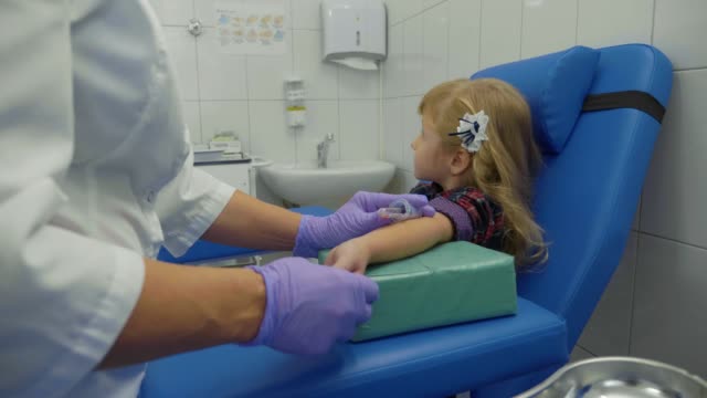 Krankenschwester-übernimmt-Blutprobe-aus-einer-Vene-in-den-Arm-des-kleinen-Mädchens