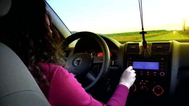 woman-driver-driving-a-car-toward-sunset,-pov